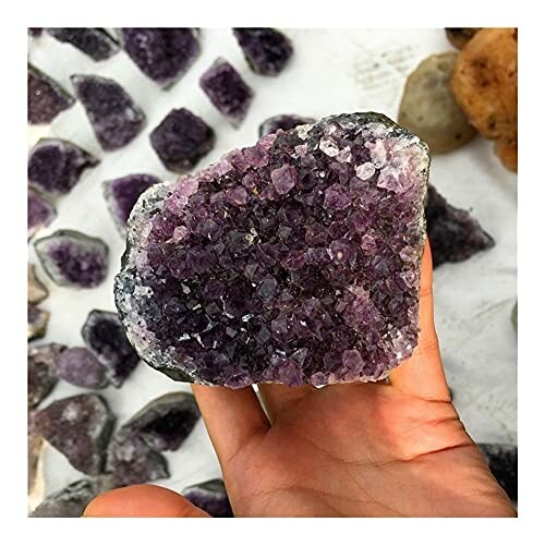 Hand som håller en ametistkristall.