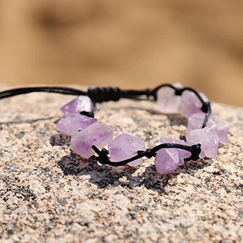 Lila ametistarmband på en sten