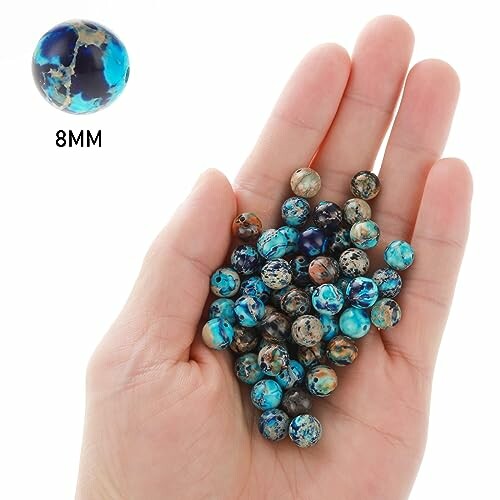 Hand som håller blå agatpärlor