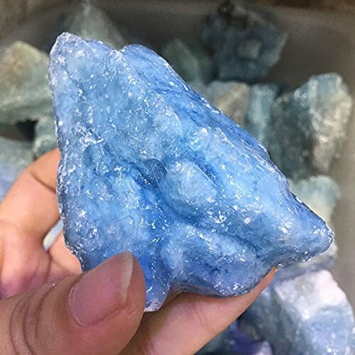 Hand som håller en blå kristallsten