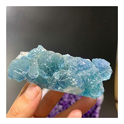 Blå mineralsten i hand.