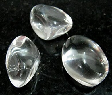 Tre klara kristallstenar på svart bakgrund.