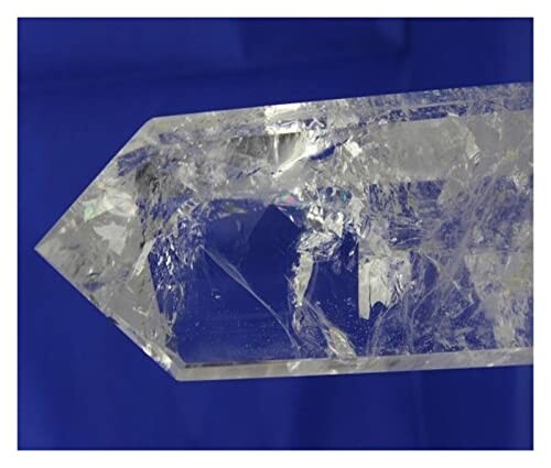 Klar kvarts kristall mot blå bakgrund.