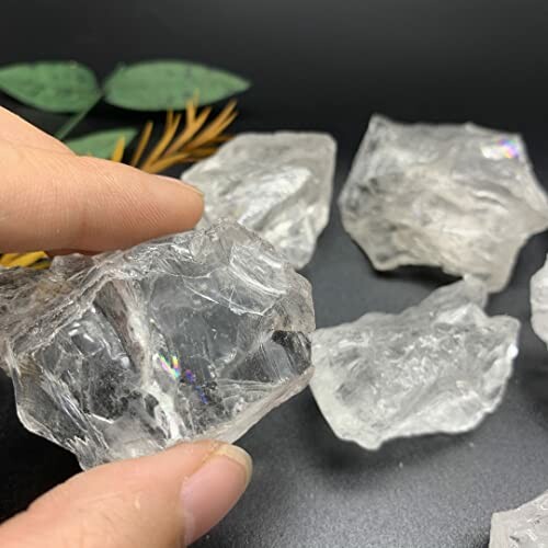 Hand håller en klar kvarts kristall.