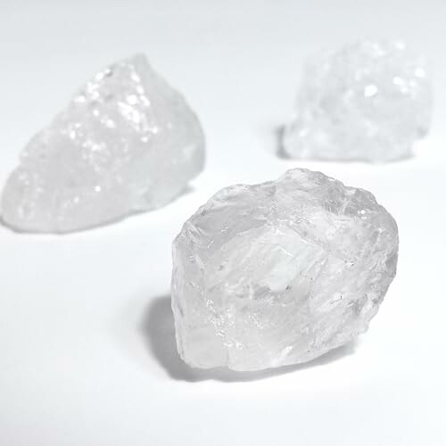 Tre klara kvarts kristaller på vit bakgrund.