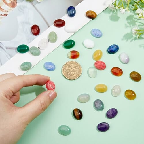 Olika färgglada ädelstenar och ett mynt på ett bord.