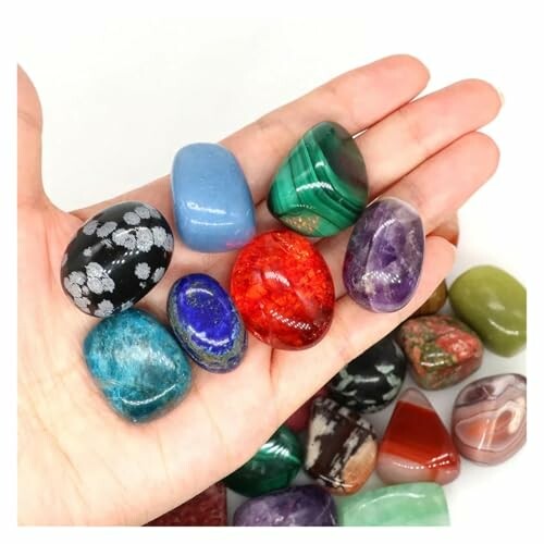 Person som håller färgglada stenar i handen.