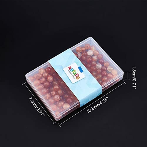 En låda med färgade pärlor i olika nyanser.