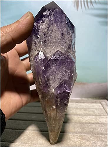 Hand håller en ametistkristall