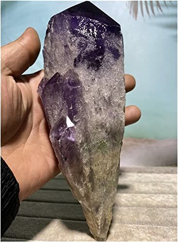 Hand som håller en ametistkristall