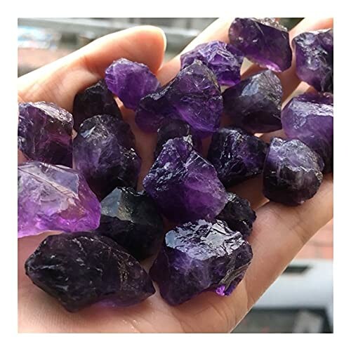 Hand håller ametistkristaller