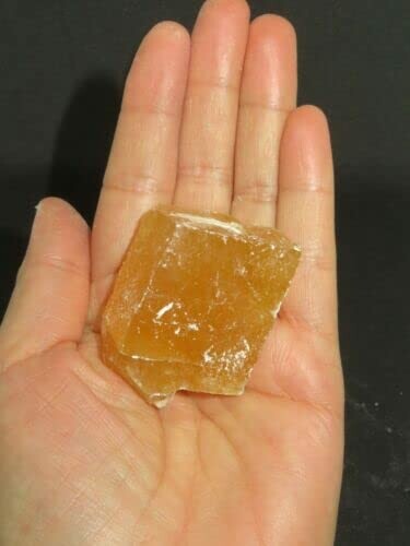 Hand som håller en brun kristall.