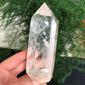 Hand håller en klar kristall.