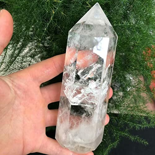 Hand som håller en klar kvarts kristall.