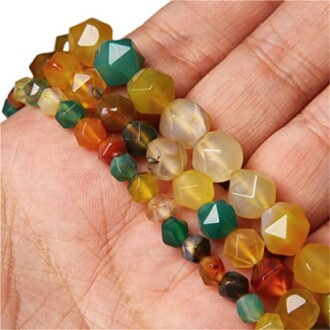 Hand som håller färgglada pärlor