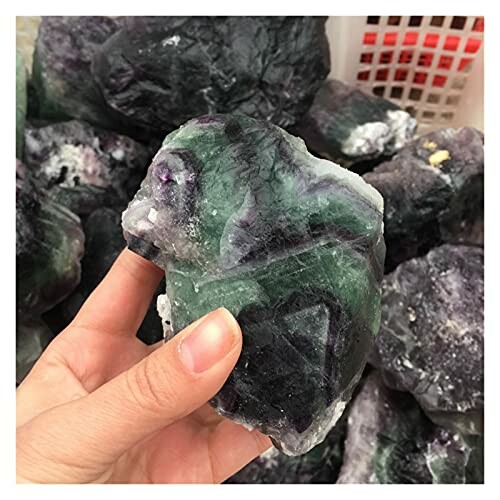 Hand håller en fluoritkristall.