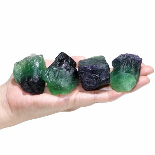 Fyra fluoritkristaller i handen.