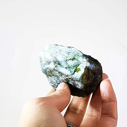 Hand håller ett labradoritsten.