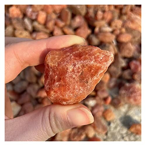 Hand som håller en orange kristall