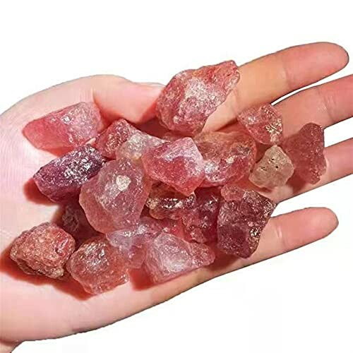 Hand håller rosa kristaller