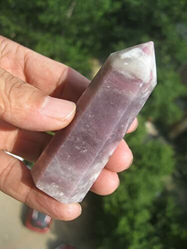 Hand som håller en lila kristall