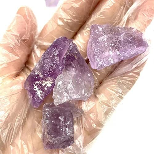 Hand som håller råa ametistkristaller