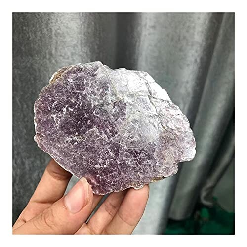 Hand som håller en rå ametist.