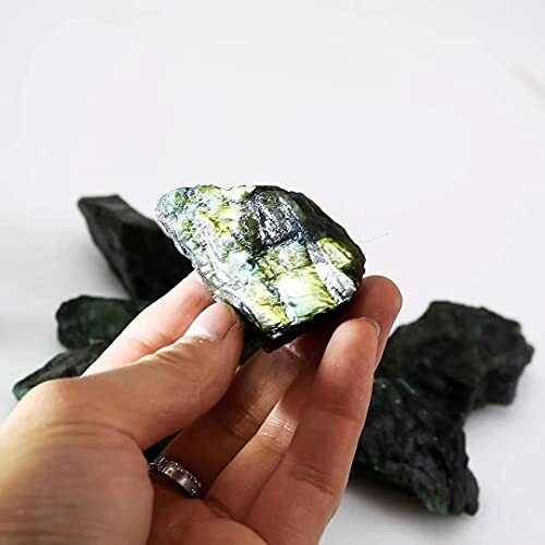 Hand håller en rå kristall