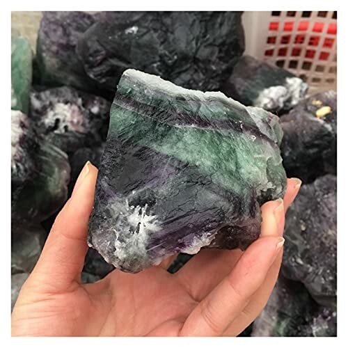 Hand som håller en rå fluoritkristall.