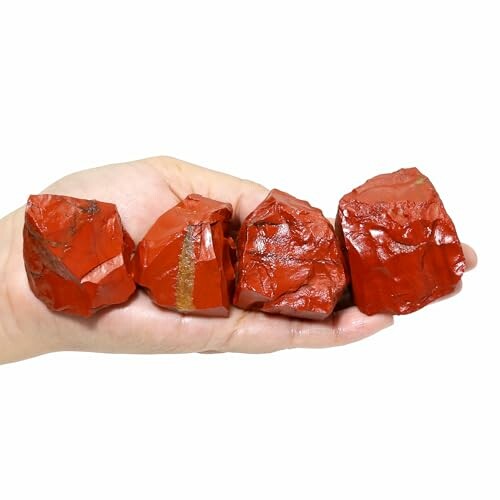 Hand som håller röda stenar