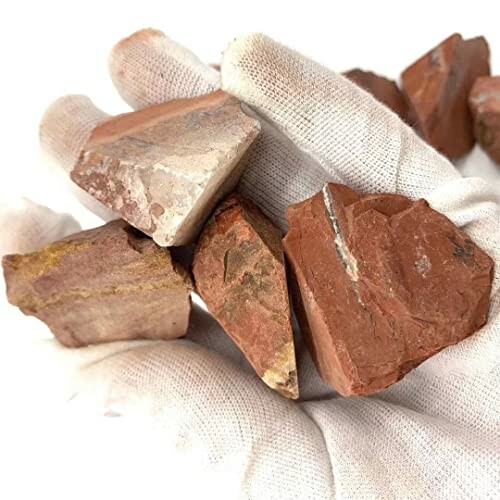 Hand som håller röda stenar