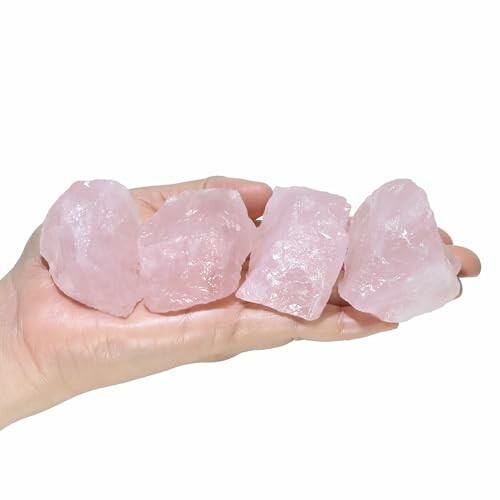 En hand som håller rosa kvartsstenar.