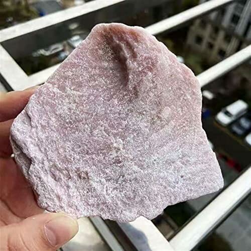 Hand håller en rosa kvartssten.