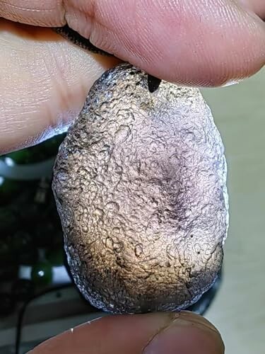 Hand håller en texturerad sten