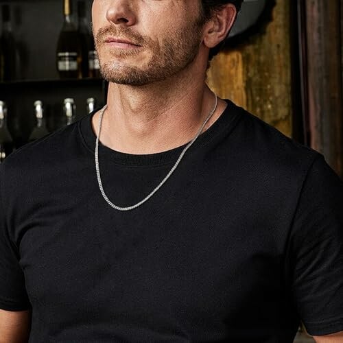 Man i svart tröja med halsband