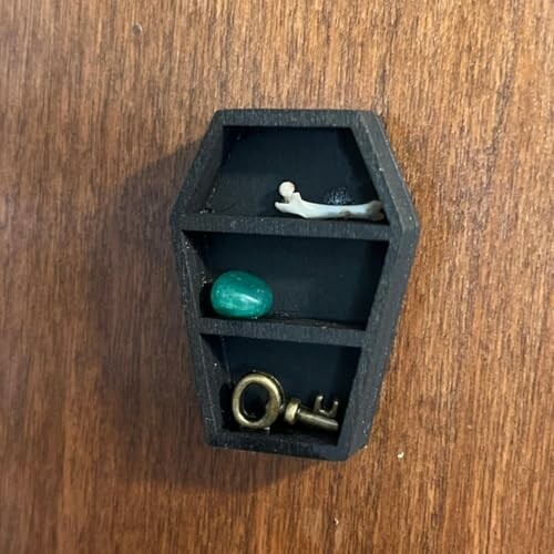 Liten kista hylla med nyckel, sten och figur