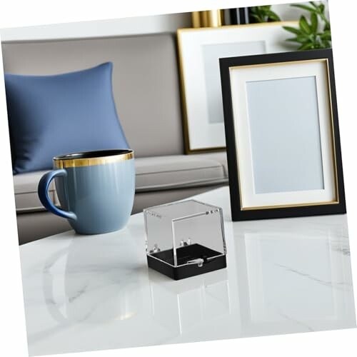 Modernt vardagsrum med mugg och ram på bord