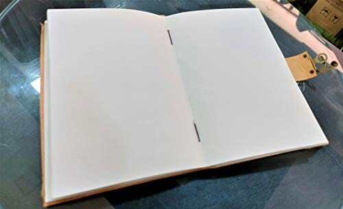 Öppen tom anteckningsbok på glasbord