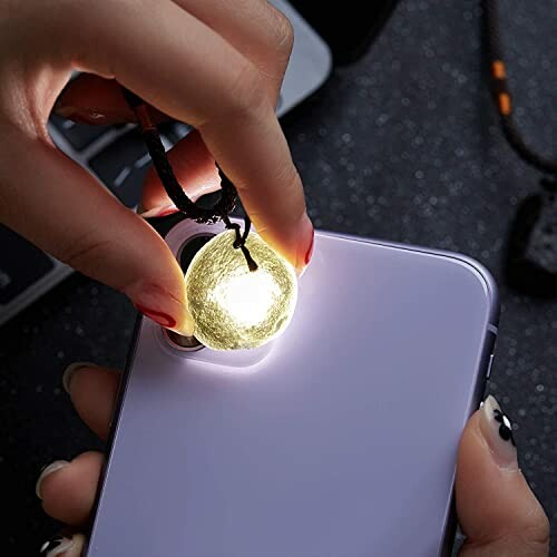 Person fäster ljus på telefonkamera