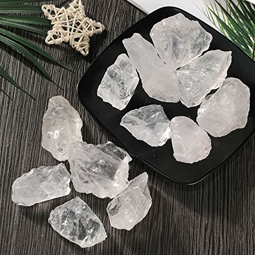 Råa klara kvartsstenar på en mörk yta och en tallrik.