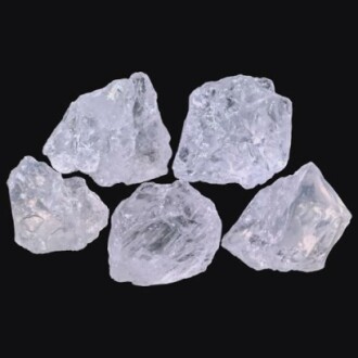 Fem rå kvarts kristaller på svart bakgrund.