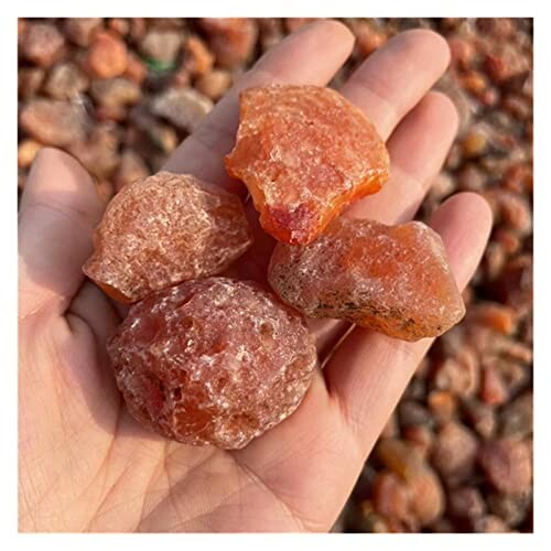 Rå röda stenar i en hand.