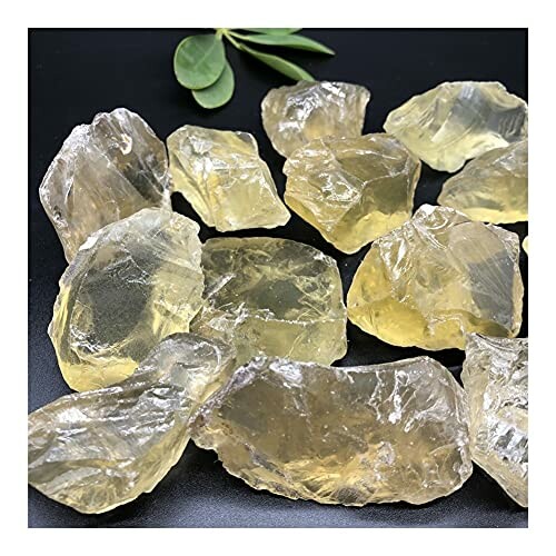 Rå gula citrinstenar på svart bakgrund