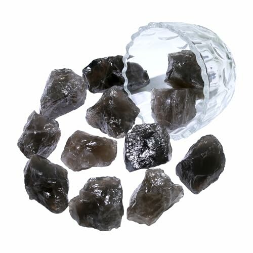 Svarta råa stenar bredvid ett glas.