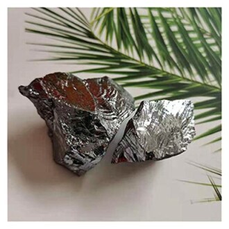 Två glänsande mineralbitar på palmblad