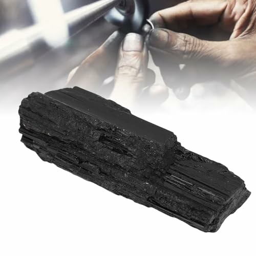 Svart shungitsten och händer som polerar