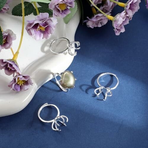 Fyra silverringar med lila blommor