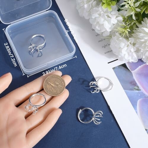 Silvriga spindelringar på ett bord med mått och blommor.