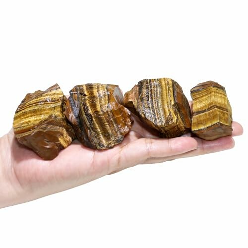 Fyra tigeröga-stenar i en hand.